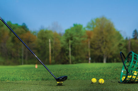 Image of a golf club about to hit a yellow ball