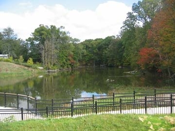 A park with a trail and pond.