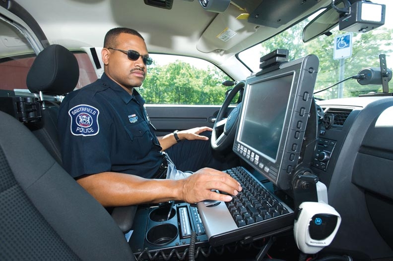 A police officer making a report in his car.