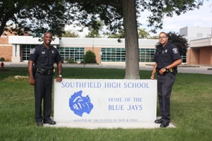 Two officers stand in front of Southfield High School