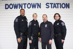 Four officers stand in front of a wall that says "Downtown Station"