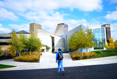 boy stands in front of building