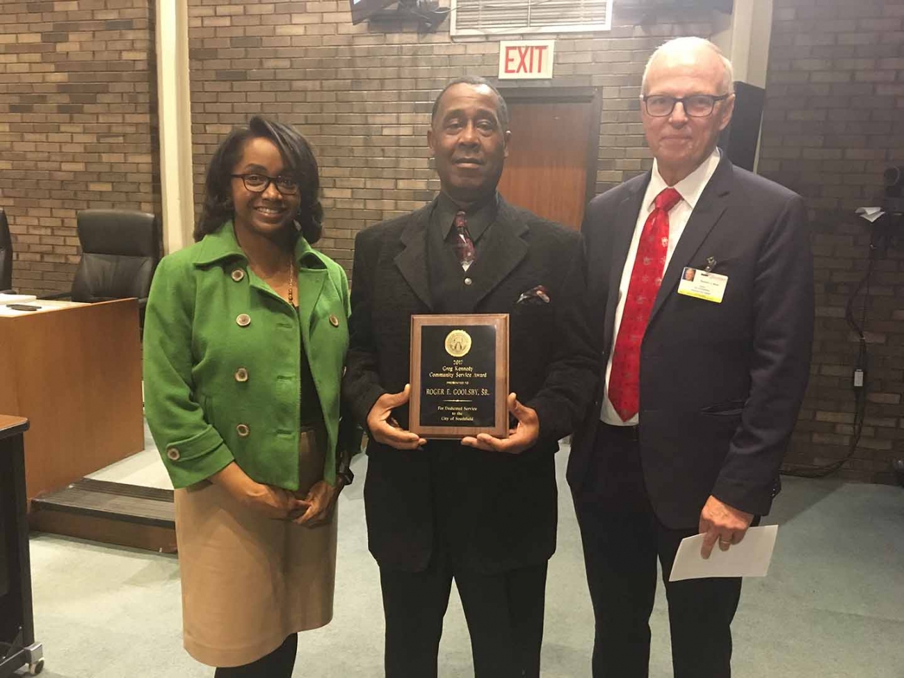 Goolsby stands with his award, the mayor, and TLC chair